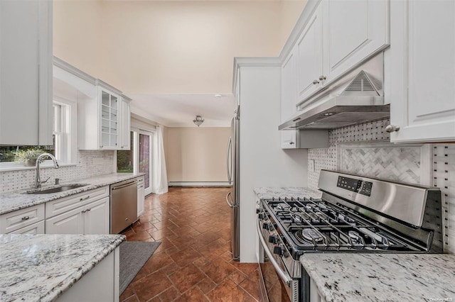 kitchen featuring light stone countertops, appliances with stainless steel finishes, tasteful backsplash, sink, and white cabinets