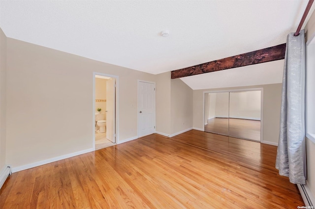 unfurnished room with beamed ceiling, hardwood / wood-style floors, and a textured ceiling