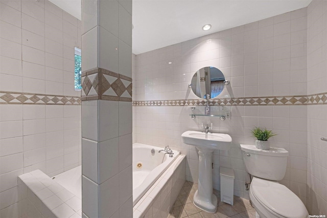 bathroom featuring tile patterned floors, toilet, tile walls, and tiled tub