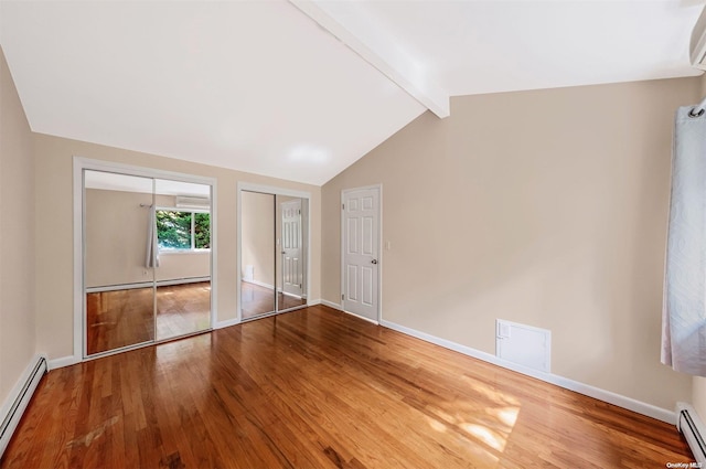 unfurnished bedroom featuring hardwood / wood-style flooring, lofted ceiling with beams, baseboard heating, and multiple closets