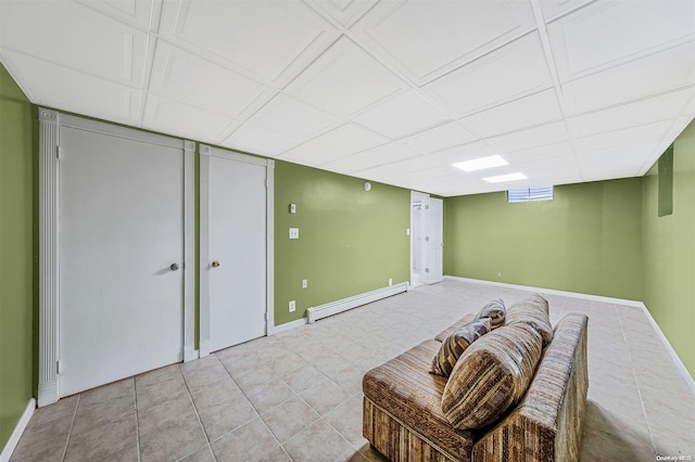 basement with light tile patterned flooring and a baseboard heating unit