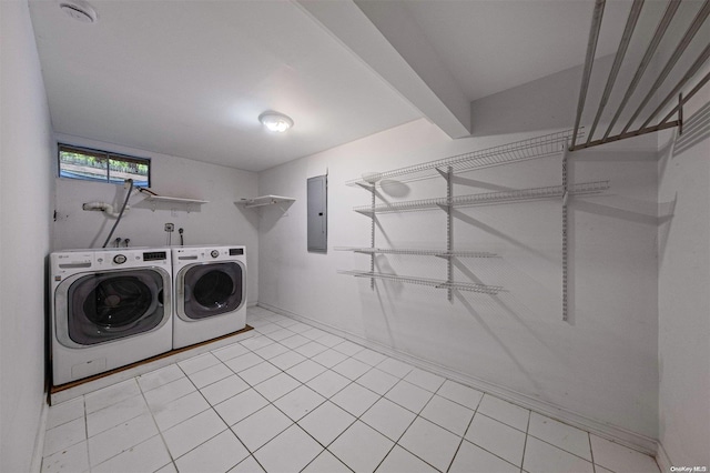 laundry area featuring washing machine and dryer, light tile patterned floors, and electric panel