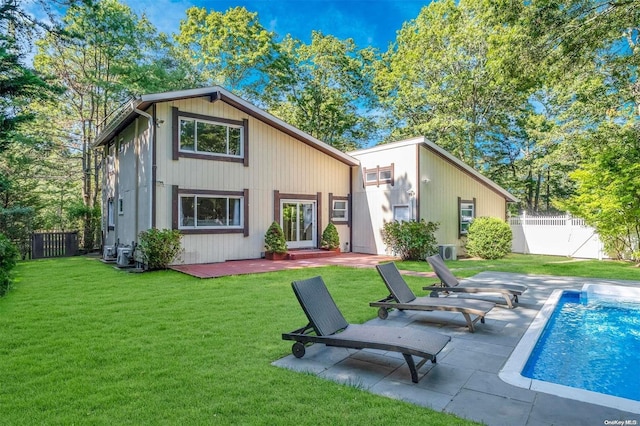 back of house featuring a patio area, a fenced in pool, and a yard