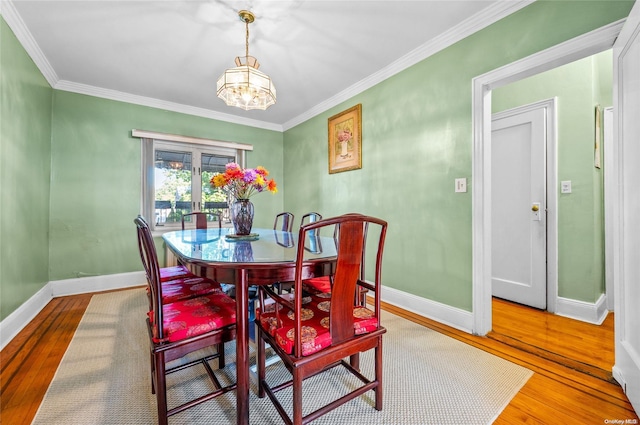 dining area featuring hardwood / wood-style floors, a notable chandelier, and ornamental molding