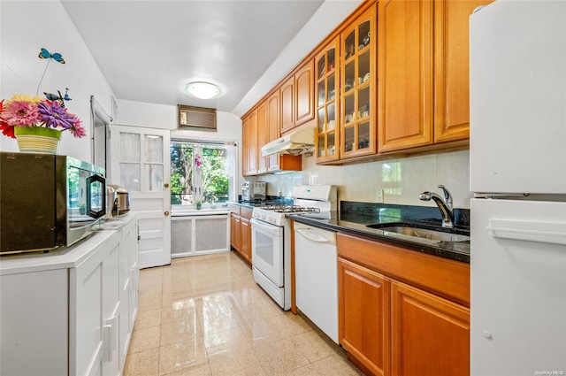 kitchen with backsplash, sink, dark stone counters, and white appliances