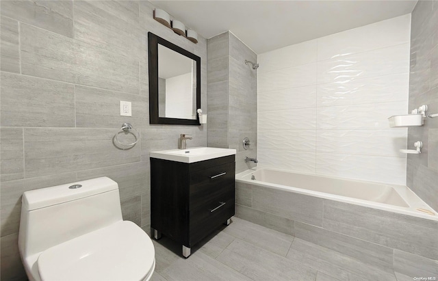 full bathroom featuring vanity, tiled shower / bath combo, and tile walls