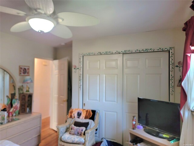 bedroom with a closet, light hardwood / wood-style floors, and ceiling fan