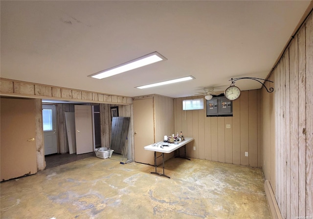 basement featuring electric panel and wooden walls