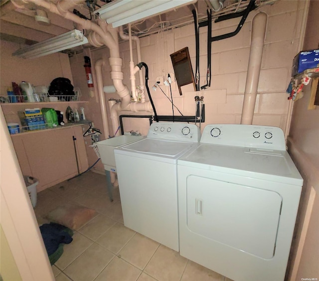 clothes washing area featuring light tile patterned floors and washing machine and dryer