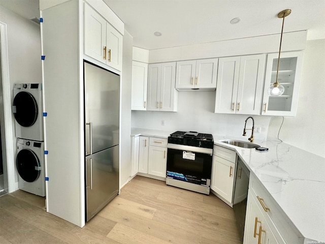 kitchen featuring white cabinetry, sink, hanging light fixtures, light hardwood / wood-style floors, and appliances with stainless steel finishes