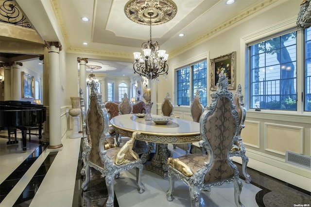 dining space with an inviting chandelier, tile patterned floors, crown molding, ornate columns, and a tray ceiling