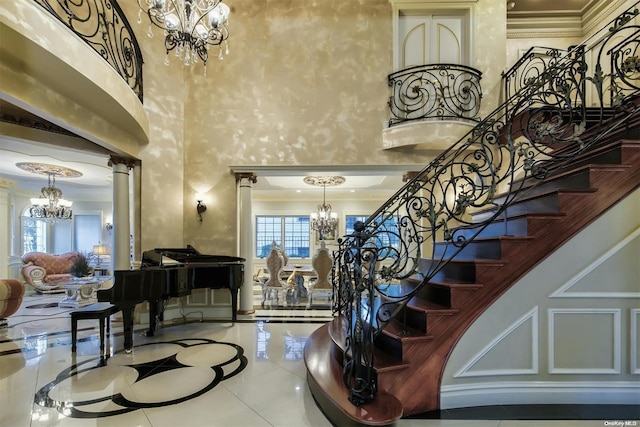 interior space featuring tile patterned flooring, ornamental molding, a high ceiling, and decorative columns