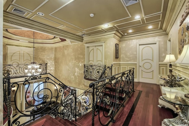 hallway featuring a notable chandelier, dark hardwood / wood-style flooring, ornamental molding, and coffered ceiling