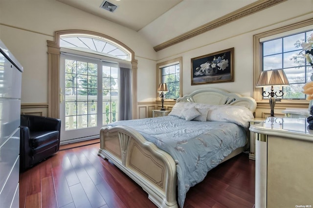 bedroom featuring dark hardwood / wood-style floors, lofted ceiling, and multiple windows