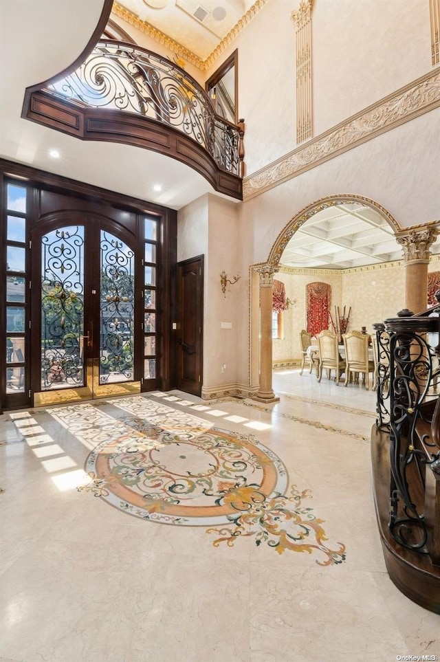 foyer entrance featuring a towering ceiling and french doors