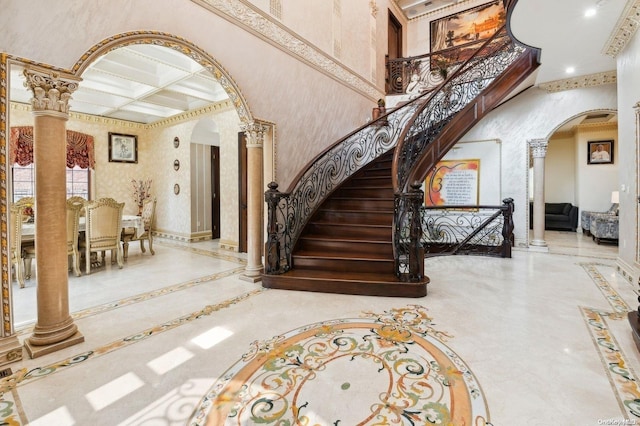 staircase featuring beam ceiling, decorative columns, a high ceiling, and coffered ceiling