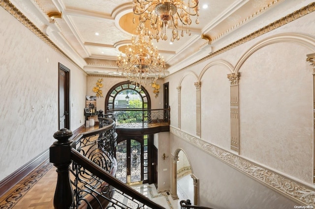 hallway with a notable chandelier, plenty of natural light, crown molding, and french doors