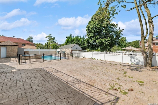 view of patio featuring a fenced in pool and an outbuilding