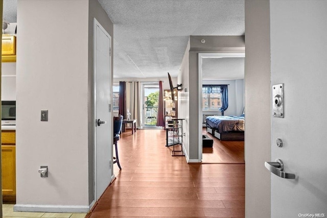 hallway with hardwood / wood-style flooring and a textured ceiling