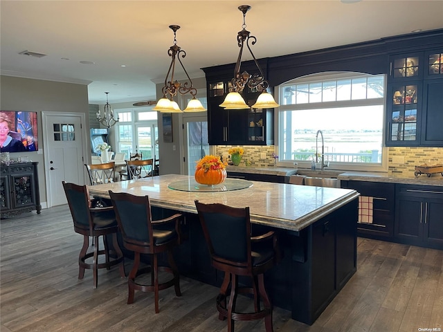 kitchen featuring blue cabinetry, dark hardwood / wood-style floors, a kitchen island, and a healthy amount of sunlight