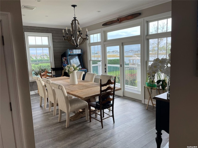 dining room featuring a chandelier, hardwood / wood-style flooring, and crown molding