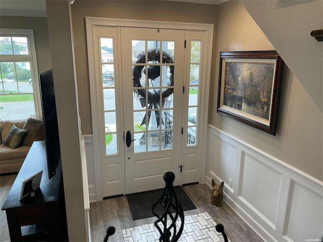 doorway to outside with hardwood / wood-style floors and crown molding