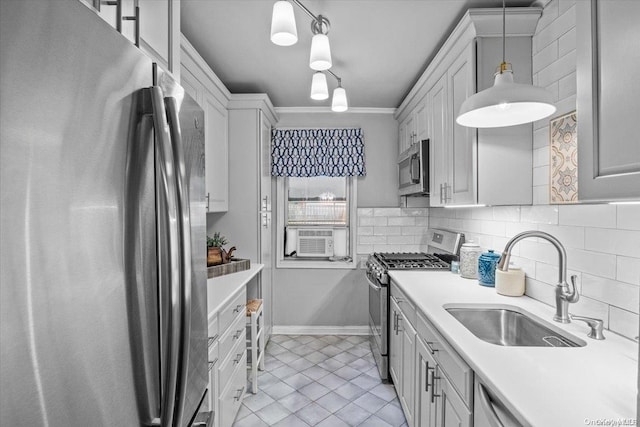 kitchen featuring pendant lighting, sink, ornamental molding, appliances with stainless steel finishes, and tasteful backsplash