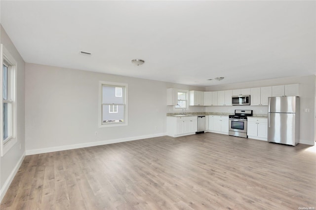 kitchen featuring sink, white cabinets, light wood-type flooring, and appliances with stainless steel finishes