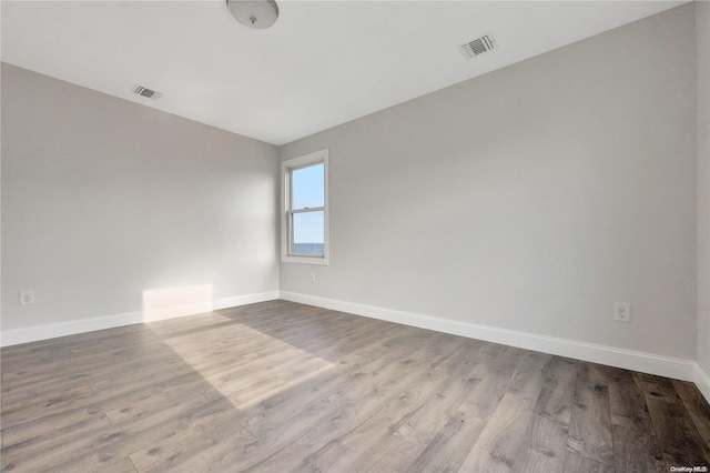 unfurnished room featuring light hardwood / wood-style floors and lofted ceiling