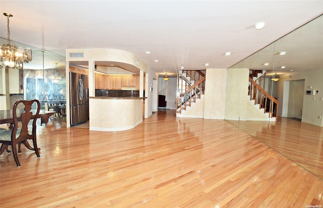 living room with light hardwood / wood-style floors and an inviting chandelier