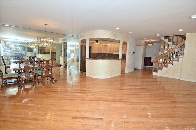 dining space with light wood-type flooring and a notable chandelier