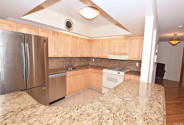 kitchen featuring light brown cabinetry, stainless steel appliances, extractor fan, and sink