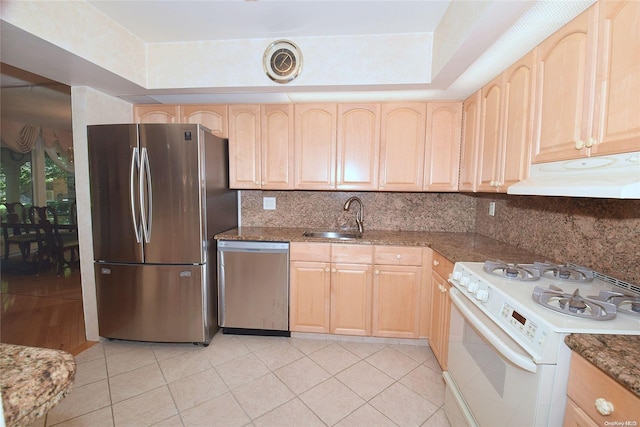 kitchen featuring appliances with stainless steel finishes, backsplash, light brown cabinetry, sink, and light tile patterned floors