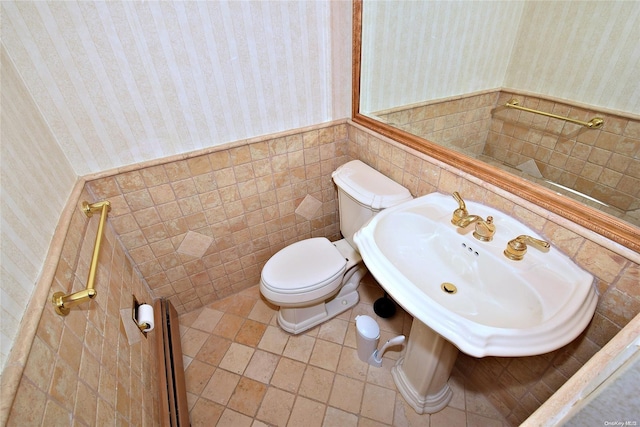 bathroom featuring tile patterned flooring, toilet, tile walls, and sink