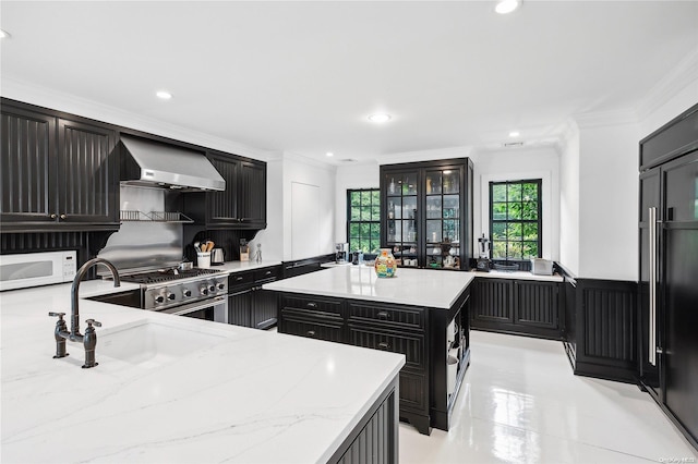 kitchen with sink, wall chimney range hood, crown molding, high end stainless steel range, and a kitchen island