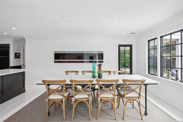 dining space with light carpet and ornamental molding