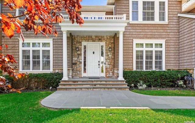 view of exterior entry with a balcony