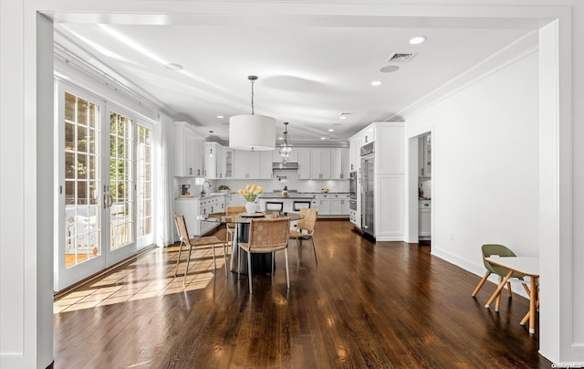 dining area featuring dark hardwood / wood-style flooring, ornamental molding, and sink