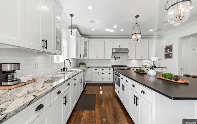 kitchen featuring white cabinets, sink, dark hardwood / wood-style flooring, and hanging light fixtures