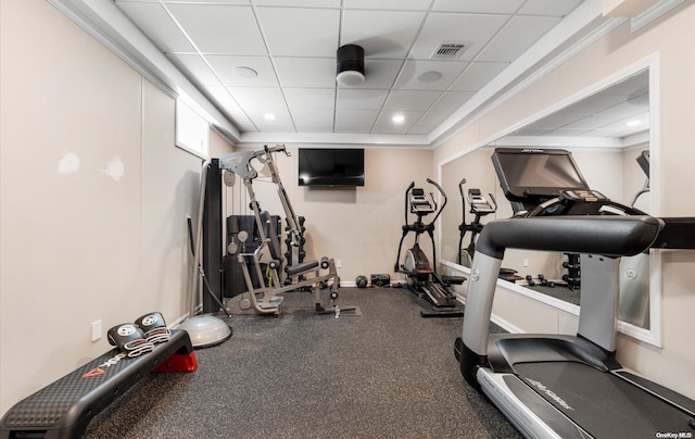 workout area with a drop ceiling and ornamental molding