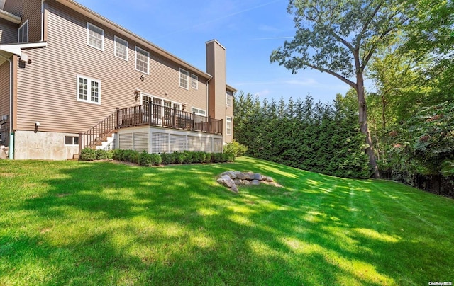 rear view of property with a yard and a wooden deck