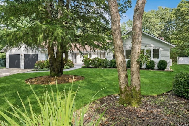 view of front of home with a garage and a front lawn