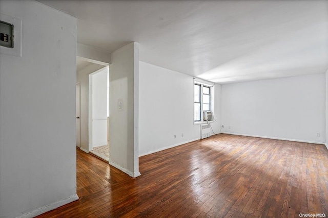 spare room with radiator heating unit and dark hardwood / wood-style floors