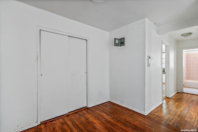 unfurnished bedroom with dark hardwood / wood-style floors and a closet