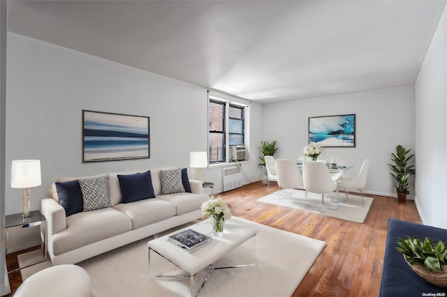 living room featuring hardwood / wood-style floors, cooling unit, and radiator heating unit