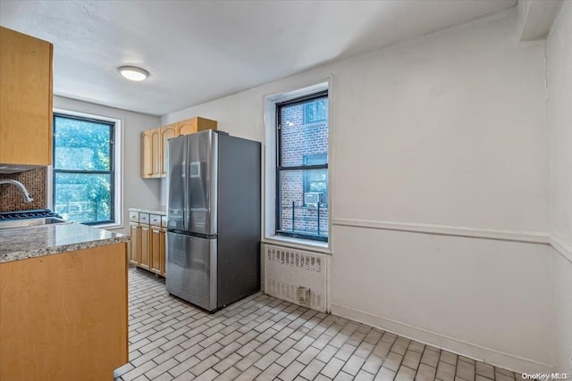 kitchen featuring stainless steel fridge, sink, plenty of natural light, and radiator