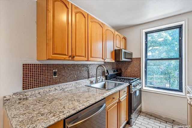 kitchen with decorative backsplash, plenty of natural light, stainless steel appliances, and sink