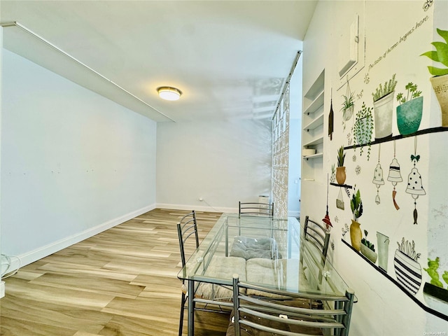 interior space with built in shelves and hardwood / wood-style flooring