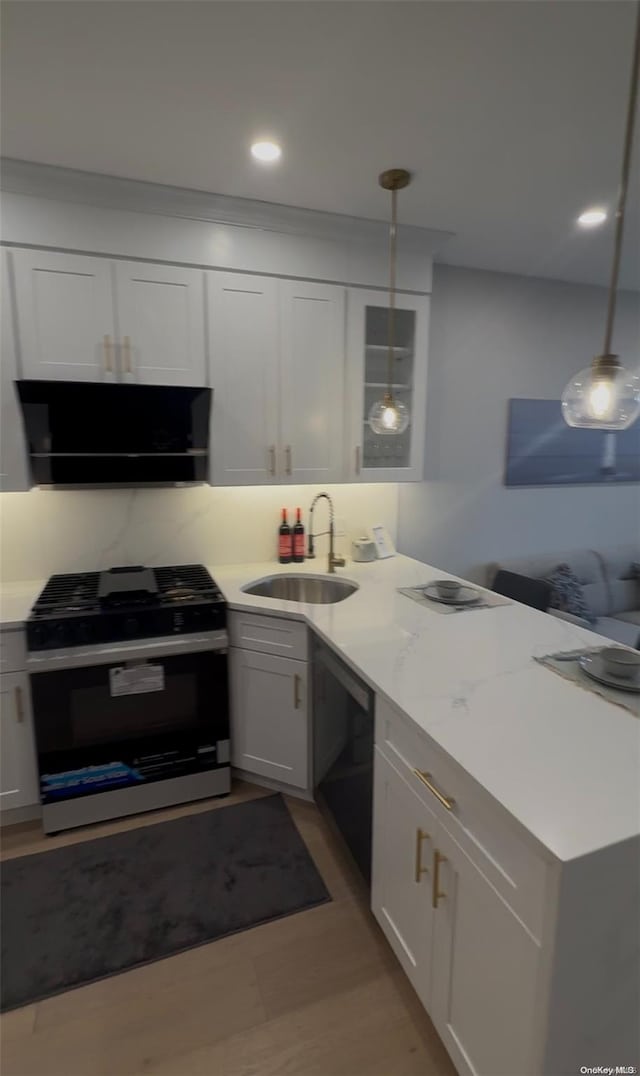 kitchen featuring gas range, white cabinetry, hanging light fixtures, and black dishwasher