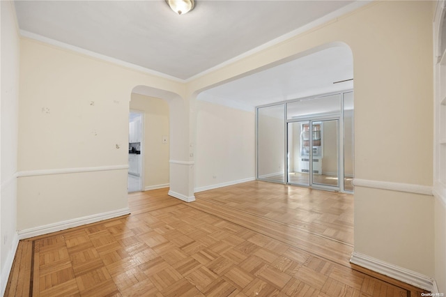 empty room with light parquet flooring and ornamental molding